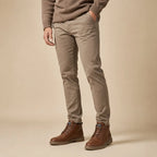 Man in taupe trousers wearing brown lace-up leather ankle boots, side view
