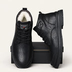 Front view of black leather lace-up ankle boots with branded tongue tab and ridged sole