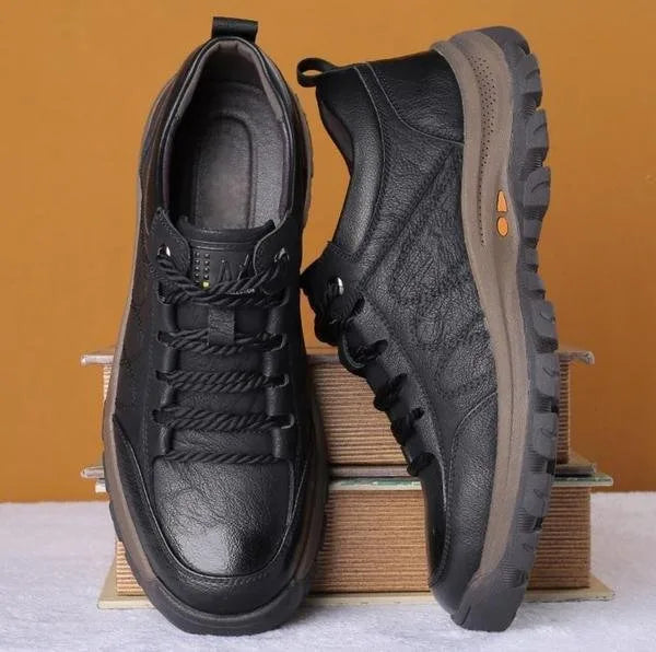 Pair of black leather shoes shown side by side, one standing and one lying on its side