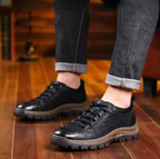 Top-down view of black leather shoe highlighting quilted panel stitching and laces
