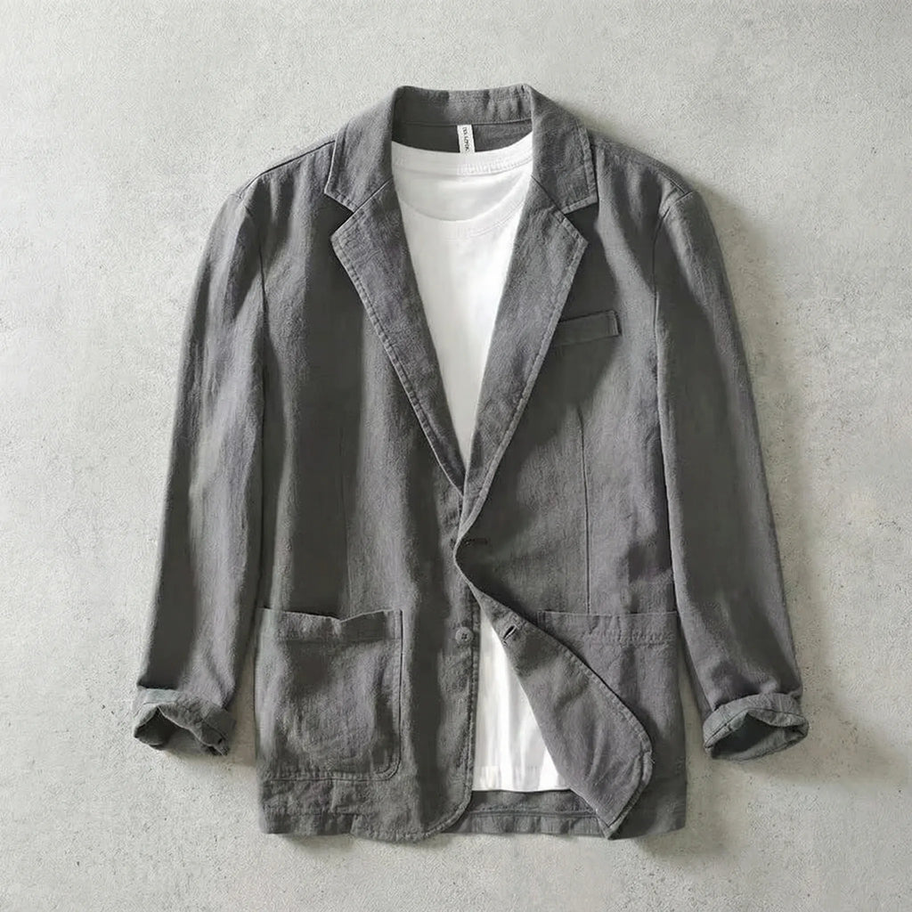 Grey linen-blend blazer worn open over a white t-shirt, showing notch lapels and chest pocket detail