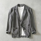Grey linen-blend blazer worn open over a white t-shirt, showing notch lapels and chest pocket detail