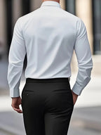 White long-sleeve shirt with sleeves rolled slightly at the cuff, showing the fabric drape and stitching