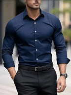 Navy blue long-sleeve dress shirt worn open-ended at the cuff, styled with a black belt and dark trousers outdoors