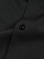 Dark grey button-down shirt shown with hand in pocket, highlighting the slim tailored fit outdoors