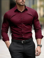 Dark red button-down dress shirt with long sleeves and pointed collar, paired with a black belt and watch