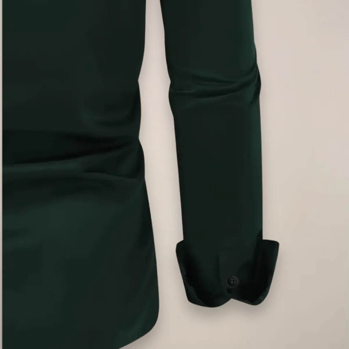 Side angle of a long sleeve button-front shirt showing the cuff detail and pointed collar shape.
