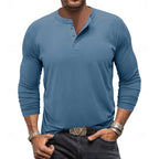 Front view of a man wearing the light grey henley with sleeves shown in full length against denim trousers