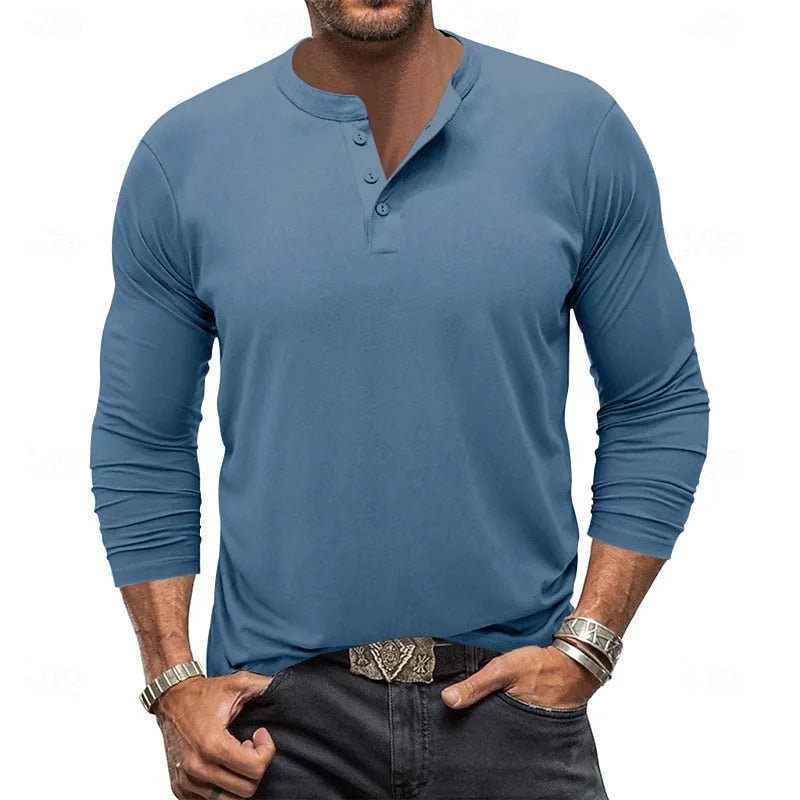Front view of a man wearing the light grey henley with sleeves shown in full length against denim trousers