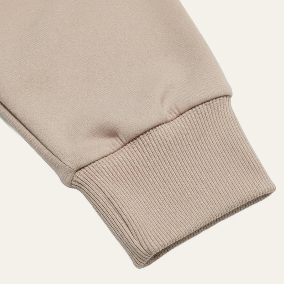 Close-up of the ribbed cuff on the sleeve of the khaki knit polo jumper