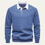 Front view of a denim blue long sleeve polo jumper with white contrast collar on a plain background
