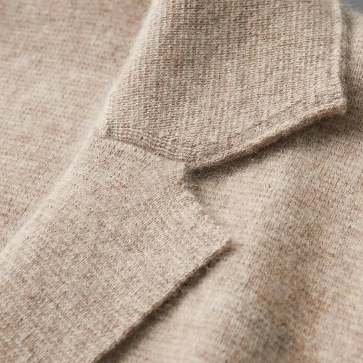 Detail shot of the button fastening and pocket stitching on a grey knitted suit-collar cardigan