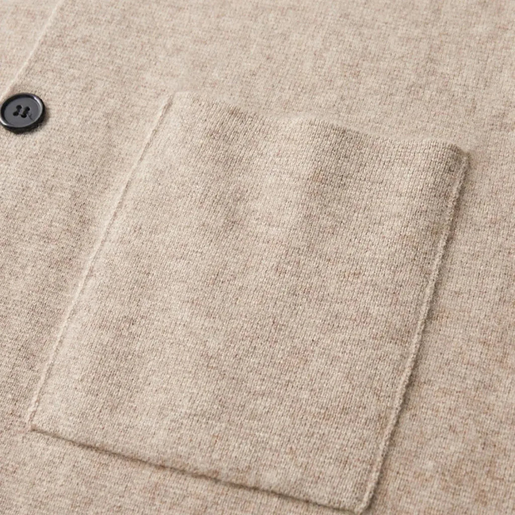 Close-up of the ribbed cuff and sleeve seam on a beige knitted blazer-style cardigan