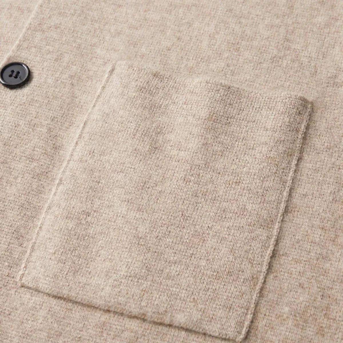 Close-up of the ribbed cuff and sleeve seam on a beige knitted blazer-style cardigan