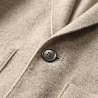 Grey knitted blazer cardigan on a hanger, three-quarter view showing collar shape and overall silhouette