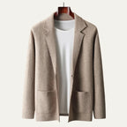 Close view of a beige knitted suit-collar cardigan on a hanger, highlighting the tailored lapel and button front