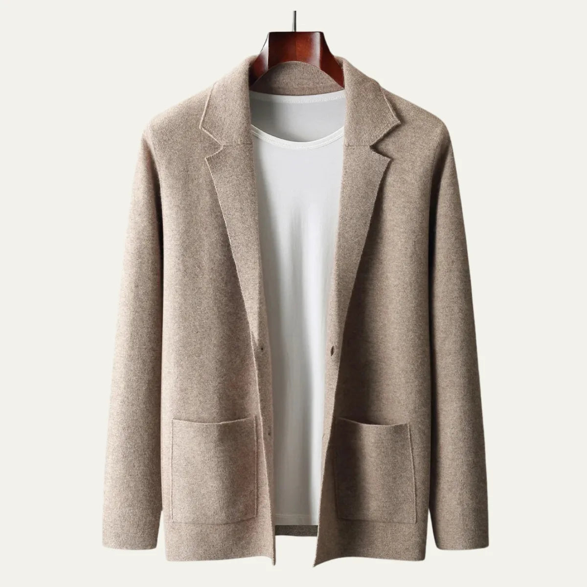 Close view of a beige knitted suit-collar cardigan on a hanger, highlighting the tailored lapel and button front