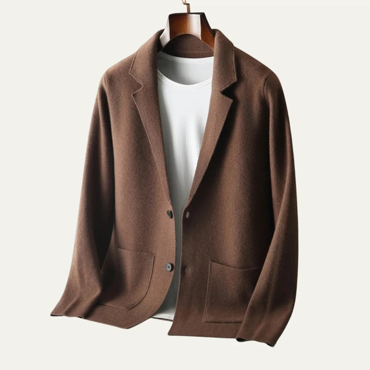 Brown knitted blazer cardigan on a hanger with buttons fastened, showing the tailored collar and front pockets