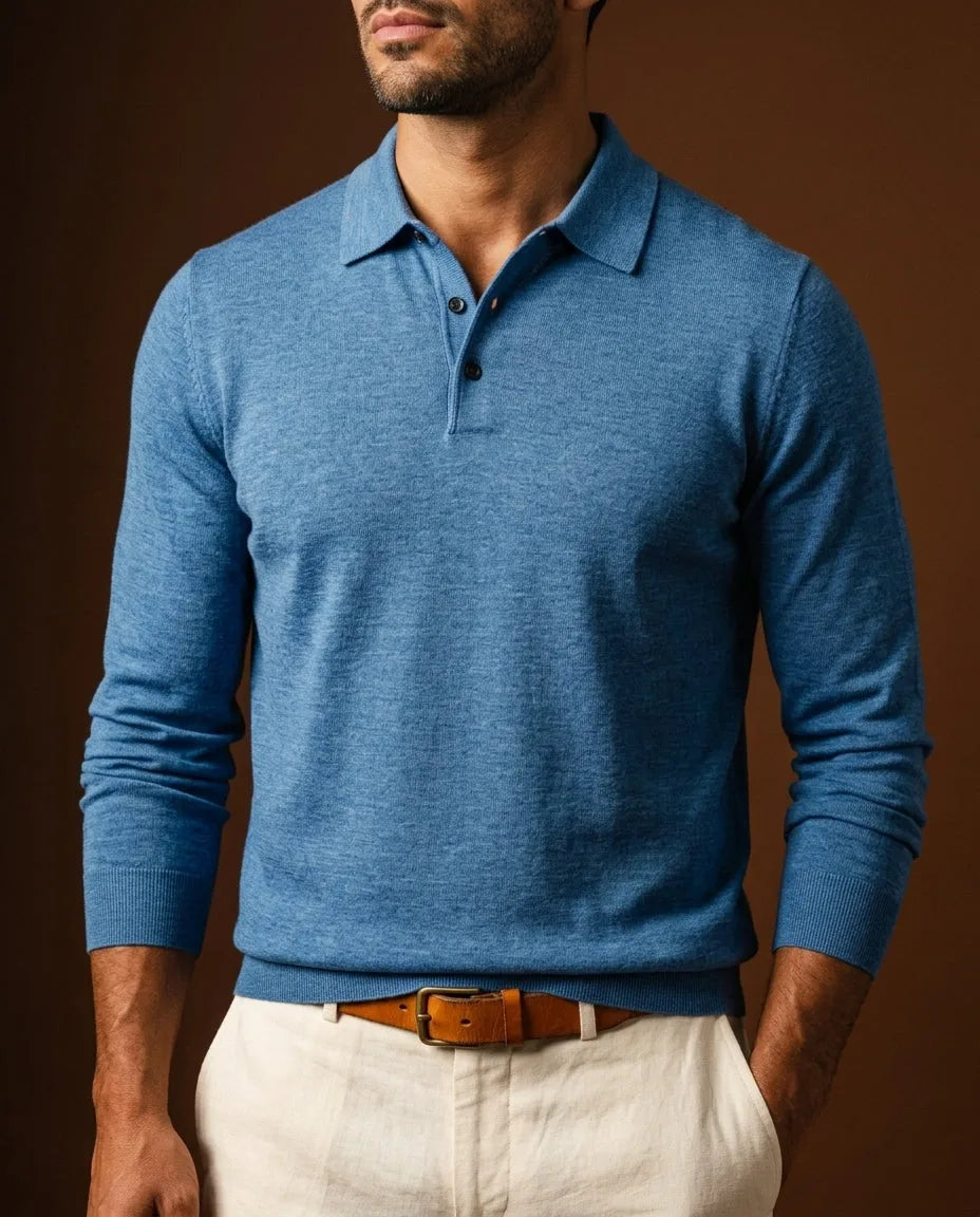 Close-up front view of a man wearing a heathered blue merino wool long-sleeve polo jumper with cream trousers