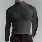 Man modelling a dark grey mock-neck top with slim long sleeves and a clean, fitted silhouette