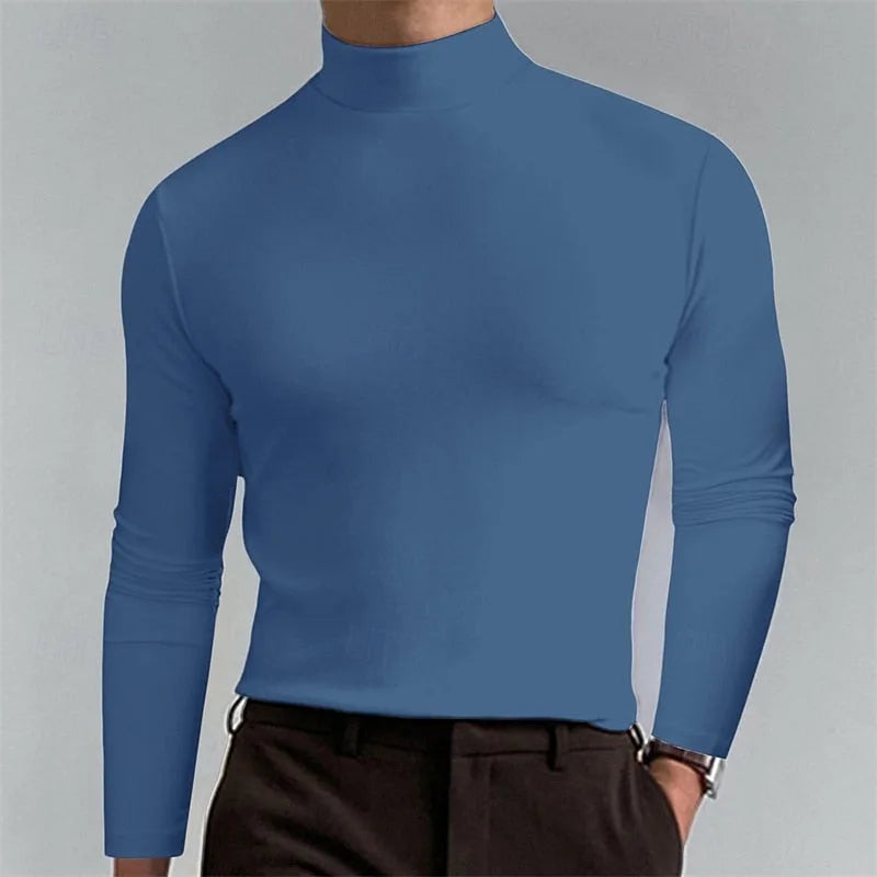 Man wearing a slate blue mock-neck jumper, showing the smooth fabric texture across the chest and arms