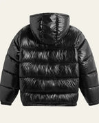 Back view of the black glossy puffer jacket showing quilted panels and hood seaming