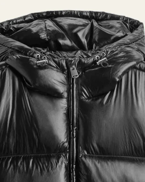 Close-up of the hood and zip puller detail on the shiny black puffer jacket