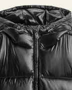 Close-up of the hood and zip puller detail on the shiny black puffer jacket