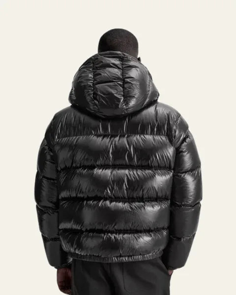Back view of a man wearing the black puffer jacket showing the hood and quilted back panel