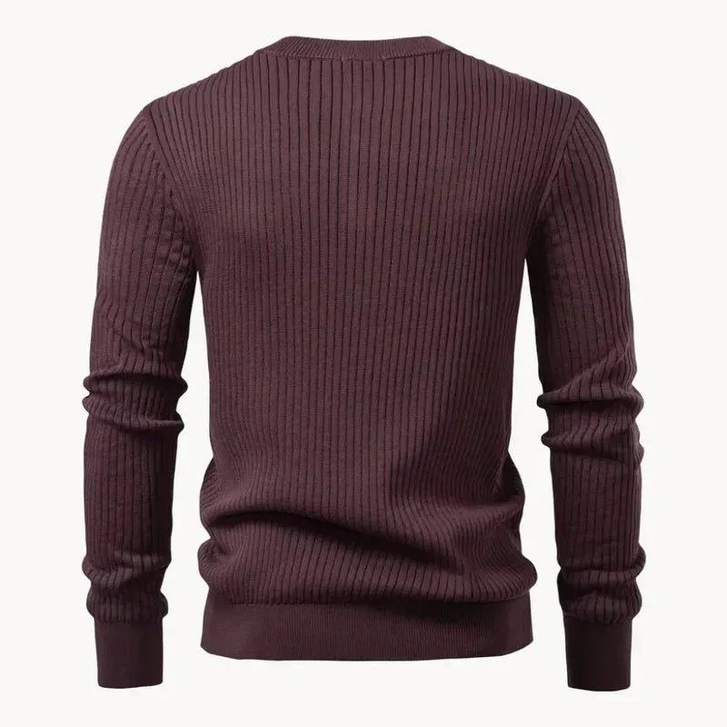 Side angle of a man wearing a black ribbed henley jumper, showing the fit through the shoulders
