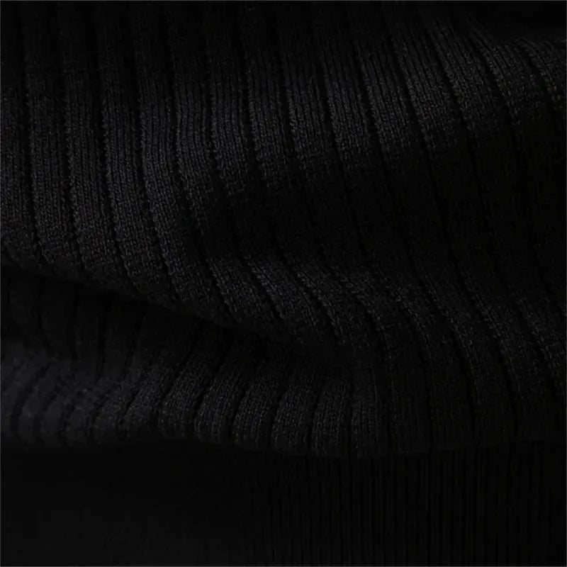 Flat lay detail of the ribbed knit cuff on a black henley jumper