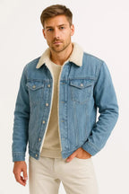 Man wearing a light blue denim jacket with cream shearling collar, open over a beige jumper