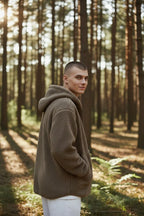 Close-up back and side view of the brown sherpa fleece hoodie with hood up, highlighting the textured fabric and seam detailing