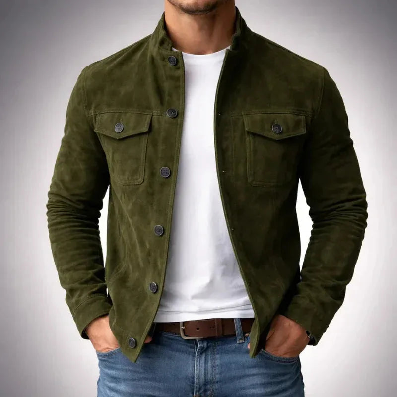Man wearing an olive green suede jacket with stand collar and chest flap pockets, buttoned over a white t-shirt