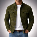 Man wearing an olive green suede jacket with stand collar and chest flap pockets, buttoned over a white t-shirt