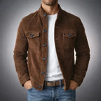Close front view of a brown suede jacket showing the stand collar, flap pockets and leather belt underneath