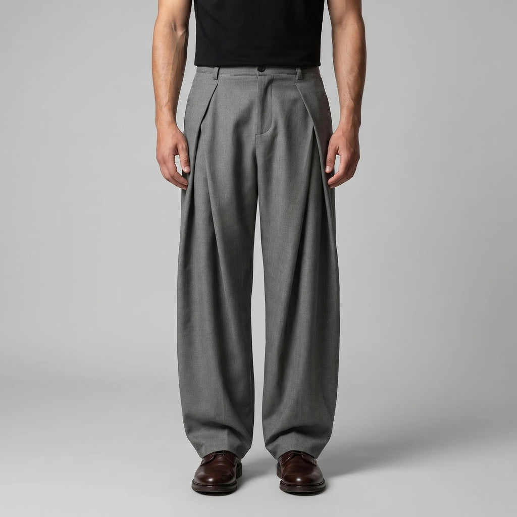 Front view of grey tailored wide-leg trousers with deep pleats, worn with a black T-shirt and brown leather shoes
