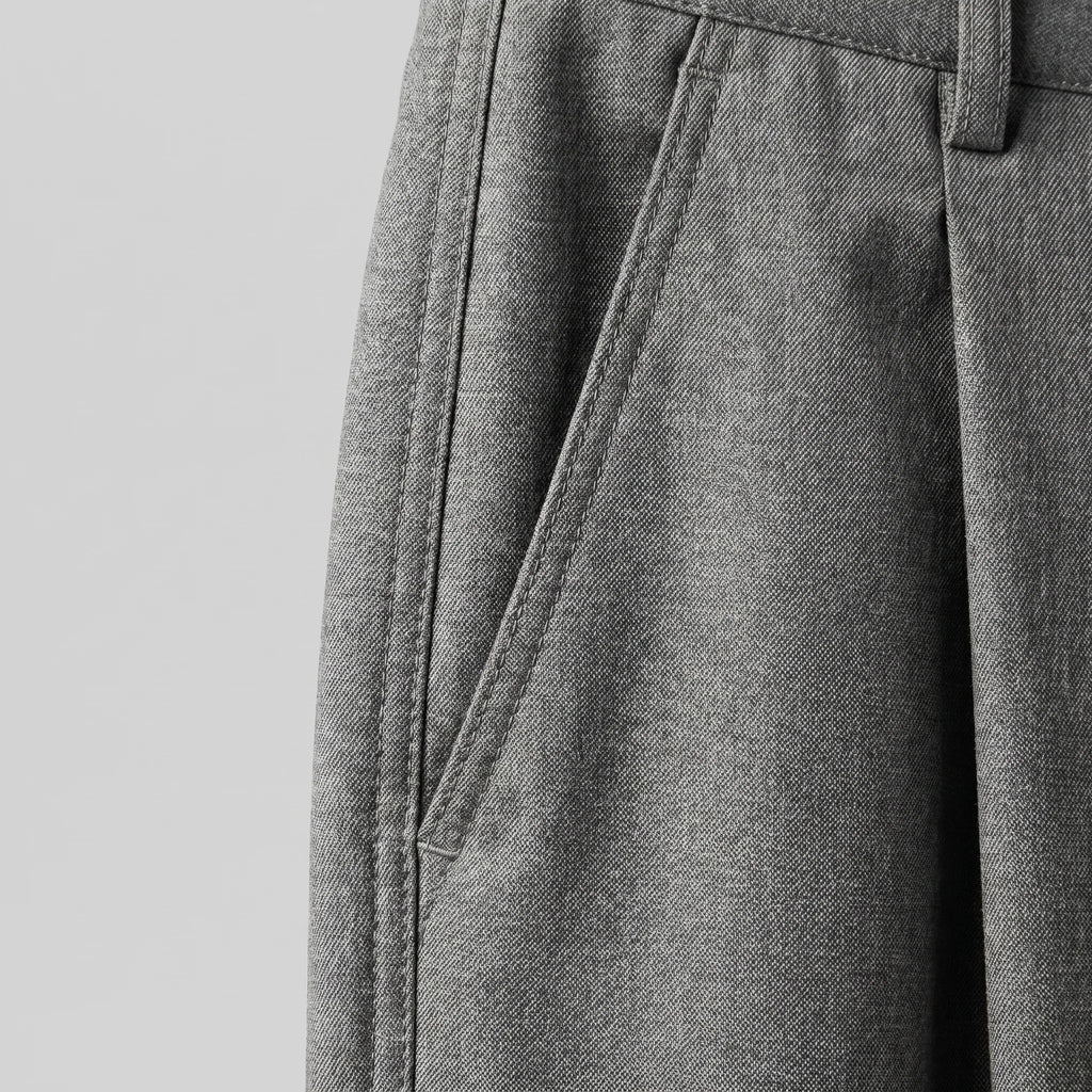 Close-up of the front pleat and pocket stitching detail on the grey wool-blend fabric