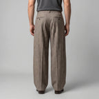 Back view of the beige tailored trousers highlighting the fitted waistband and double welt pockets
