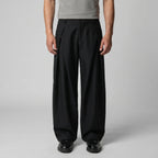 Full front view of the grey trousers paired with dark brown lace-up shoes against a plain backdrop