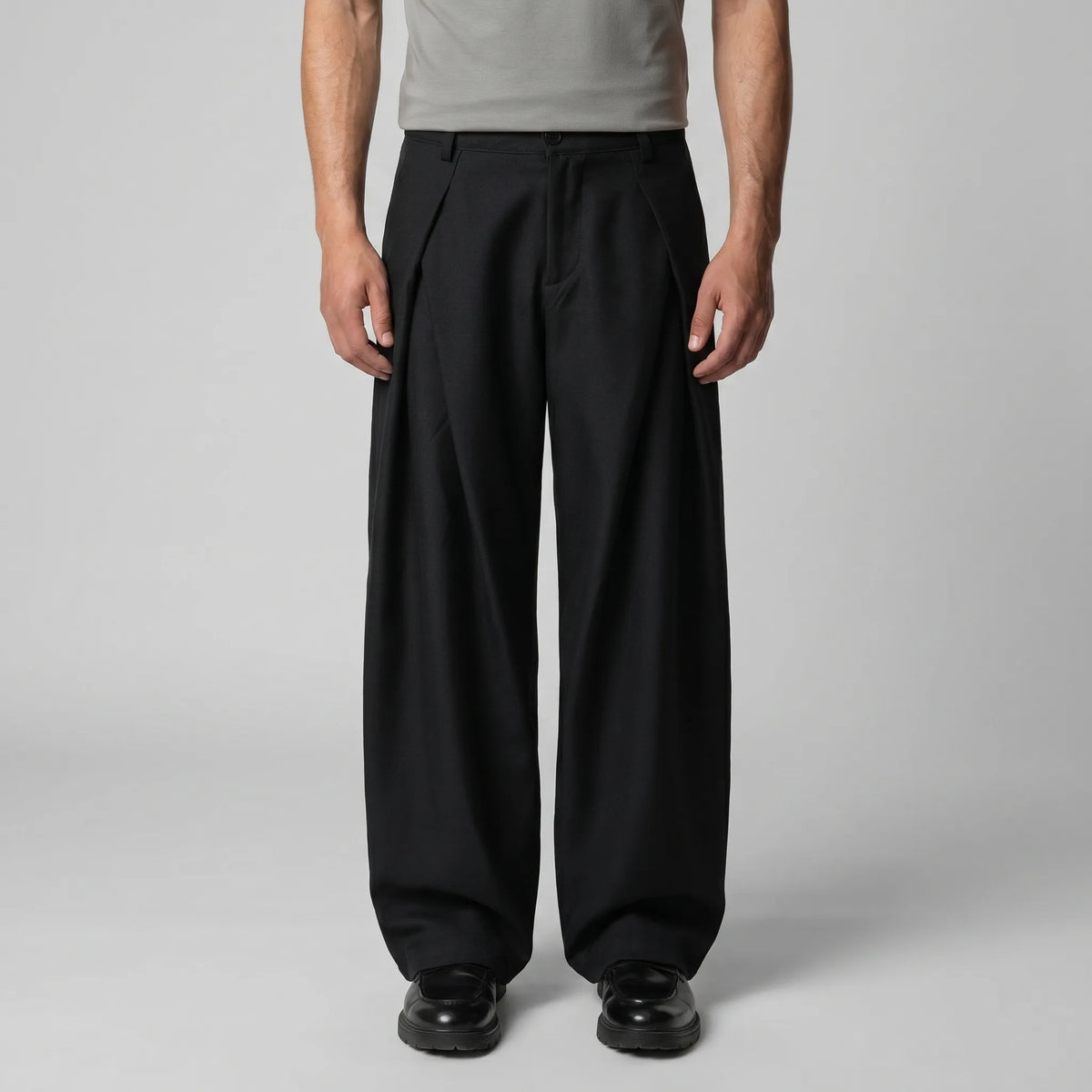 Full front view of the grey trousers paired with dark brown lace-up shoes against a plain backdrop