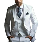Model wearing a white three-piece suit with peak lapel blazer, buttoned waistcoat and grey patterned tie