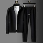 Black zip-up tracksuit jacket with white t-shirt layered underneath and matching tapered joggers on hangers