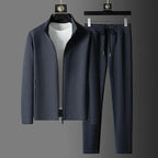 Grey twill-textured tracksuit jacket and matching joggers with drawstring waist displayed on hangers