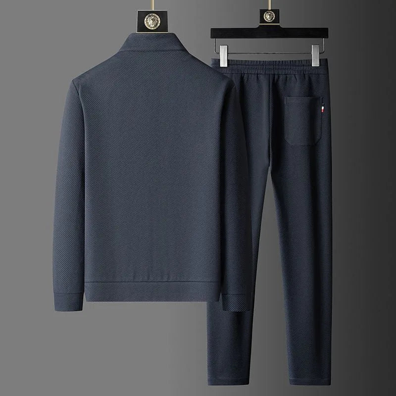 Rear view of grey tracksuit jacket and joggers showing back yoke seam and pocket with striped tab detail
