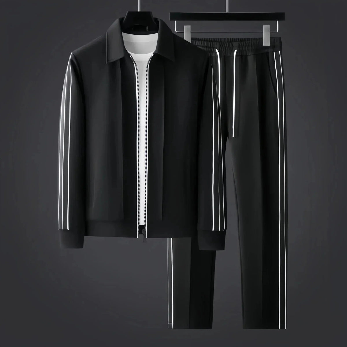 Black zip-up tracksuit jacket and trousers with white side stripes displayed on hangers against a dark grey backdrop