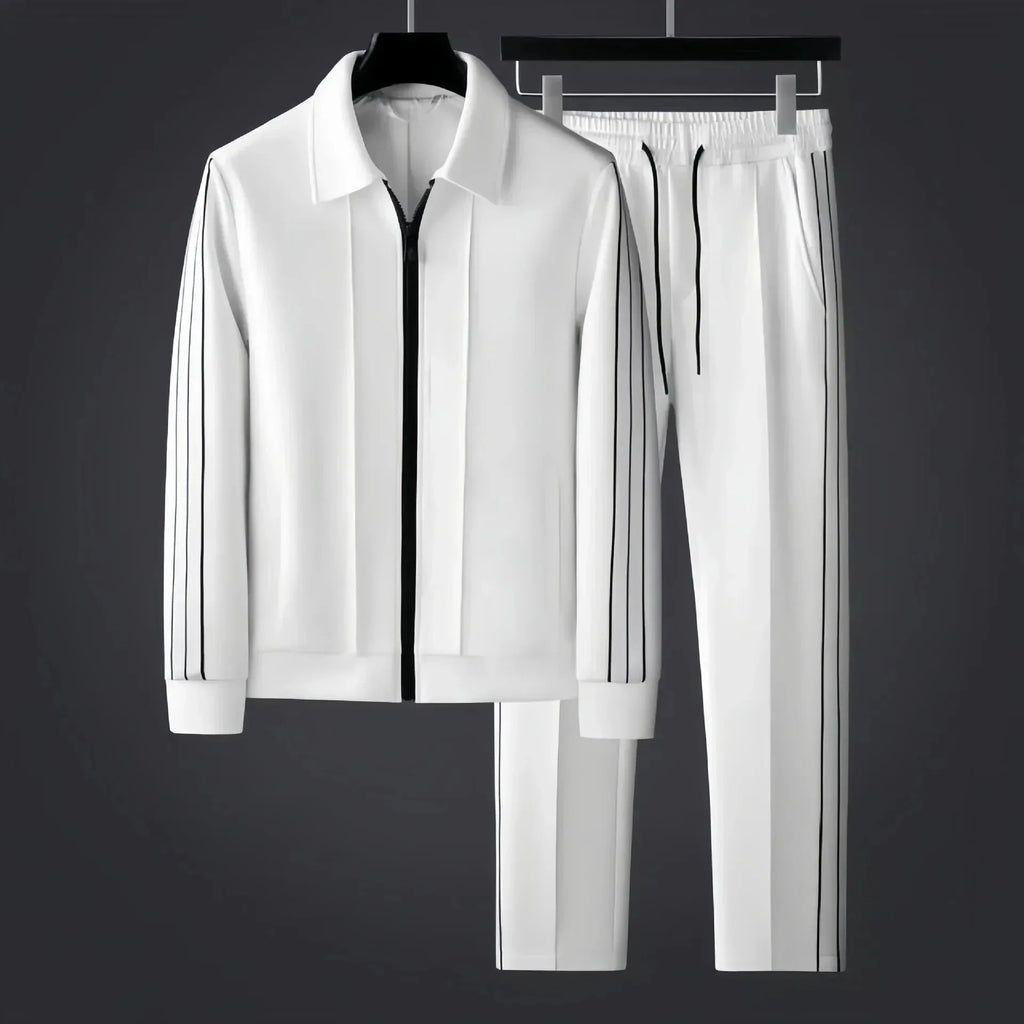 White zip-up tracksuit jacket and trousers with black side stripes shown together on hangers against a dark grey backdrop