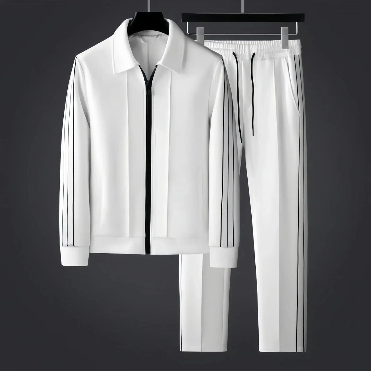 White zip-up tracksuit jacket and trousers with black side stripes shown together on hangers against a dark grey backdrop