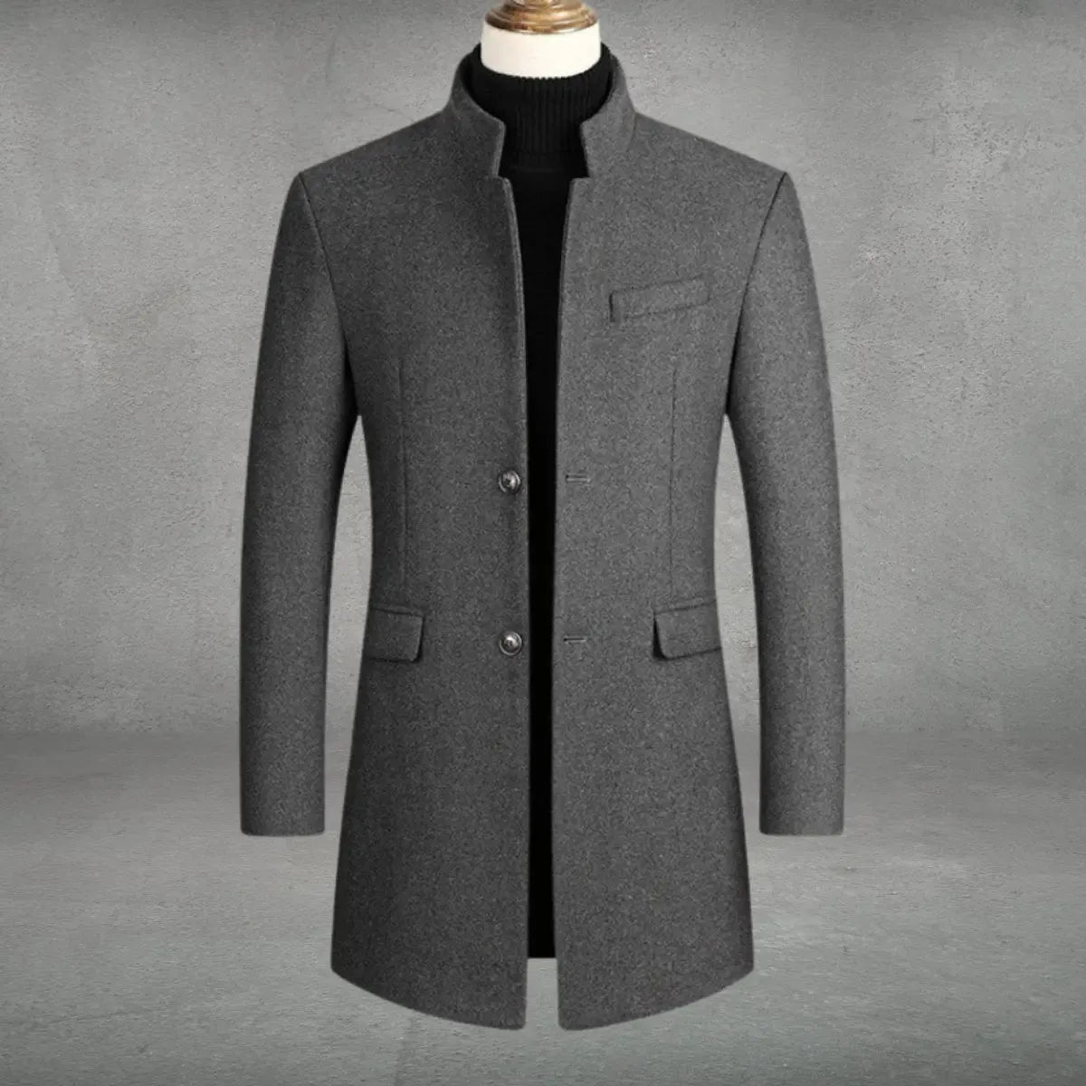 Grey wool-blend overcoat with stand collar, single-breasted button front and flap pockets, shown on mannequin with black polo neck jumper
