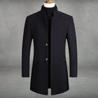Navy-black wool overcoat variant showing structured shoulders, chest welt pocket and flap side pockets in close-up front view